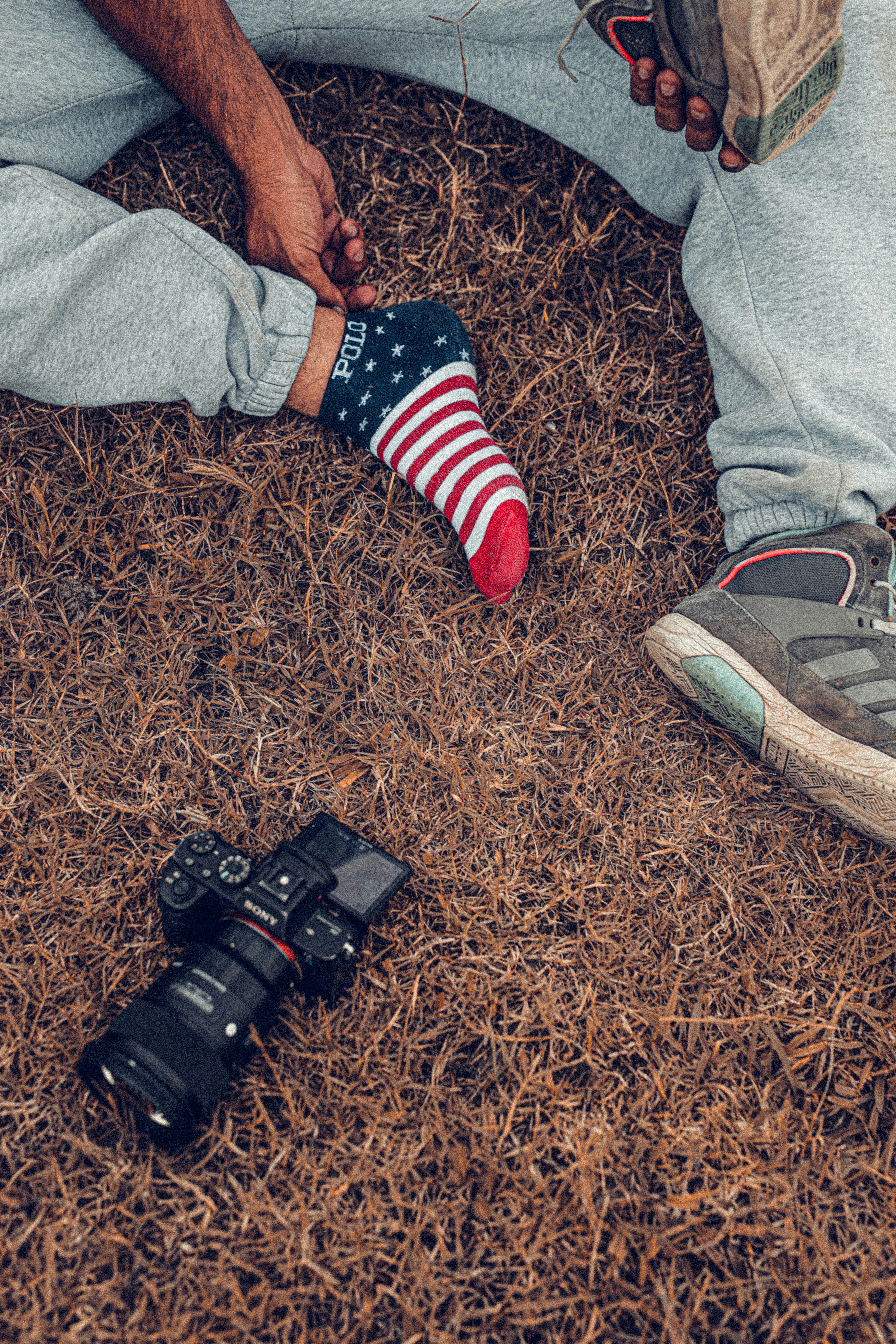 person in blue denim jeans and red socks standing on brown carpet