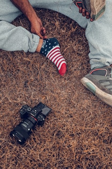 person in blue denim jeans and red socks standing on brown carpet
