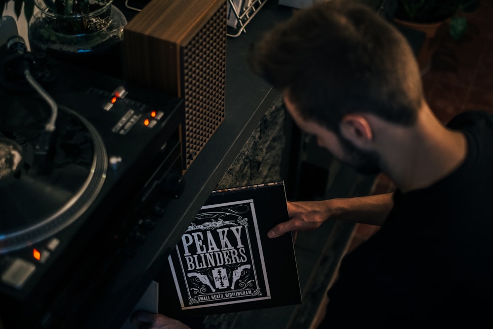 a man holding a record player in front of a record player