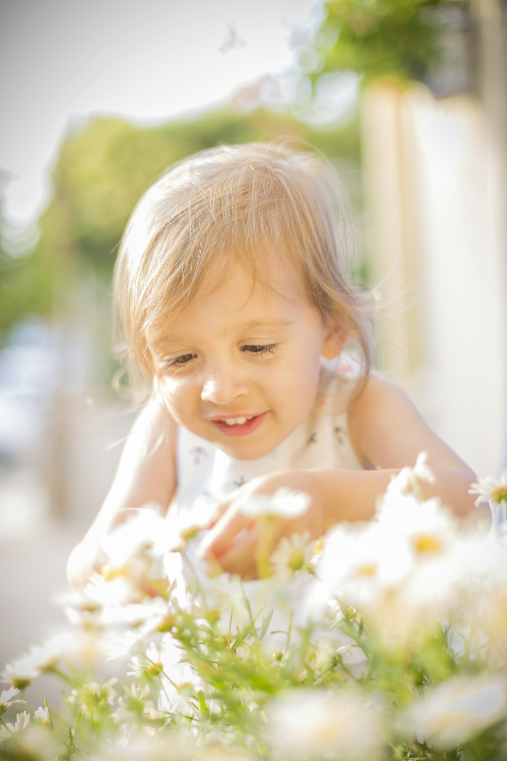 a little girl that is sitting in some flowers