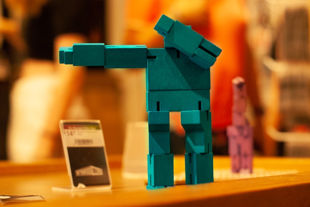 a lego dog standing next to a cell phone