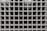 A grid of square glass blocks, each framed by white borders. The glass blocks are translucent with a textured surface, creating a pattern of reflections and refractions. The overall appearance is uniform and geometric, with a modern architectural style.