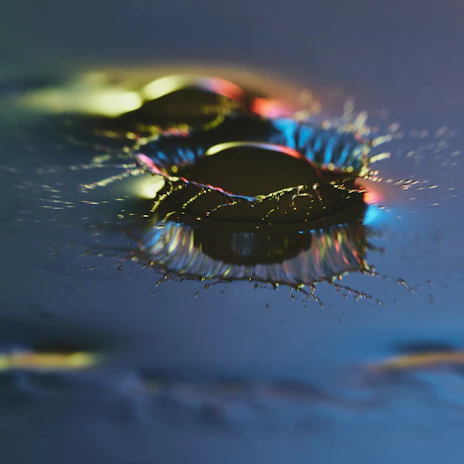 Close-up of an ink droplet creating a splash, highlighting rich and intense color saturation.