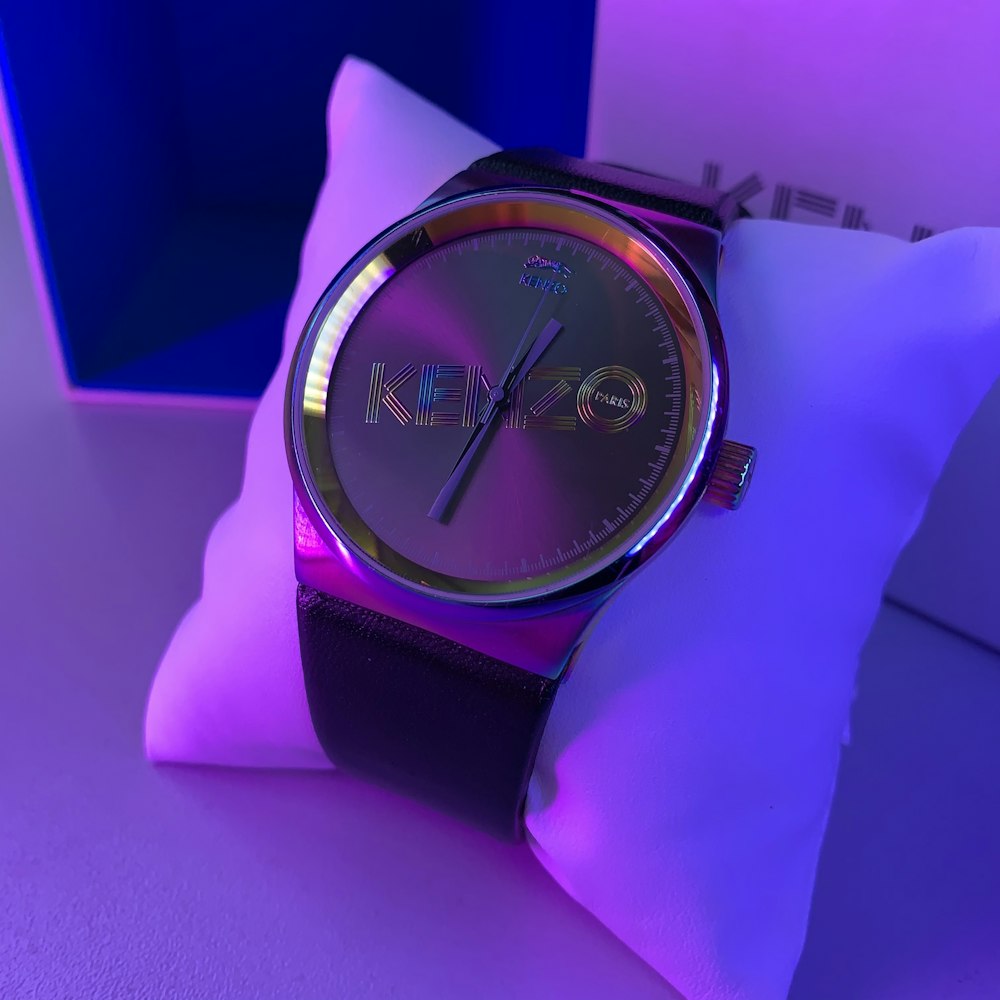 a watch sitting on top of a pillow