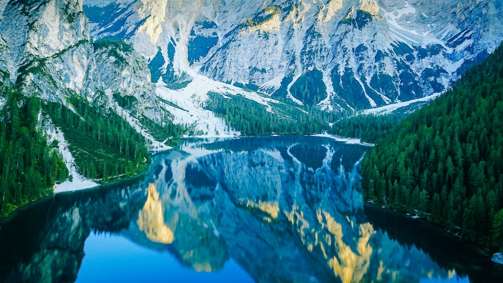Un lago de montaña rodeado de árboles y nieve