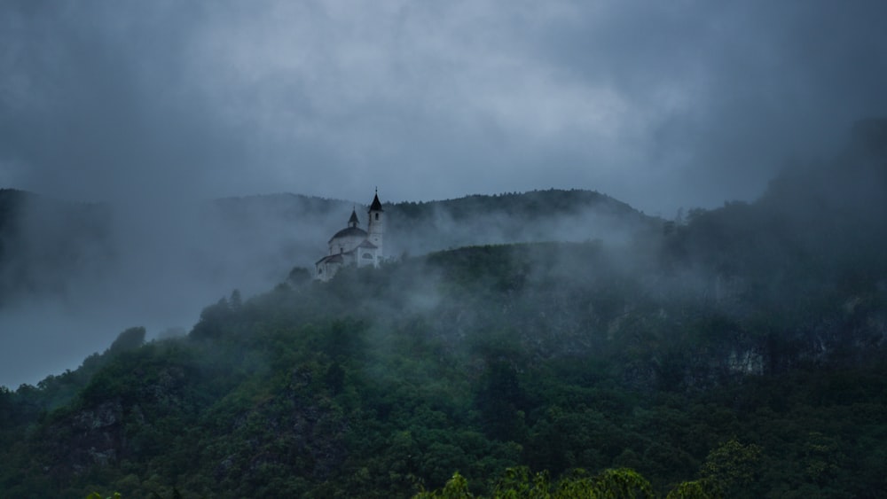 a church on a hill surrounded by fog