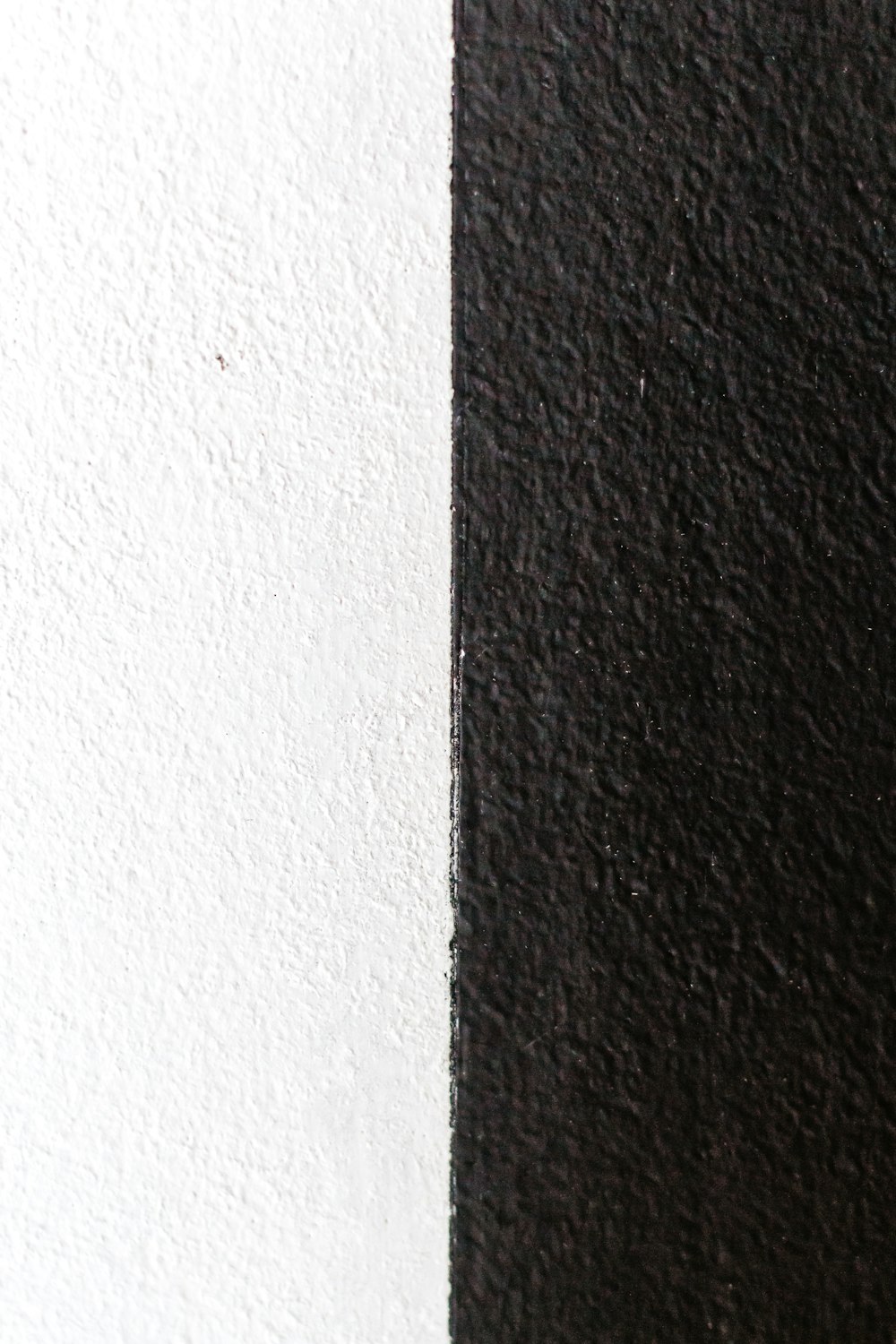 白い壁の横の黒いテキスタイル