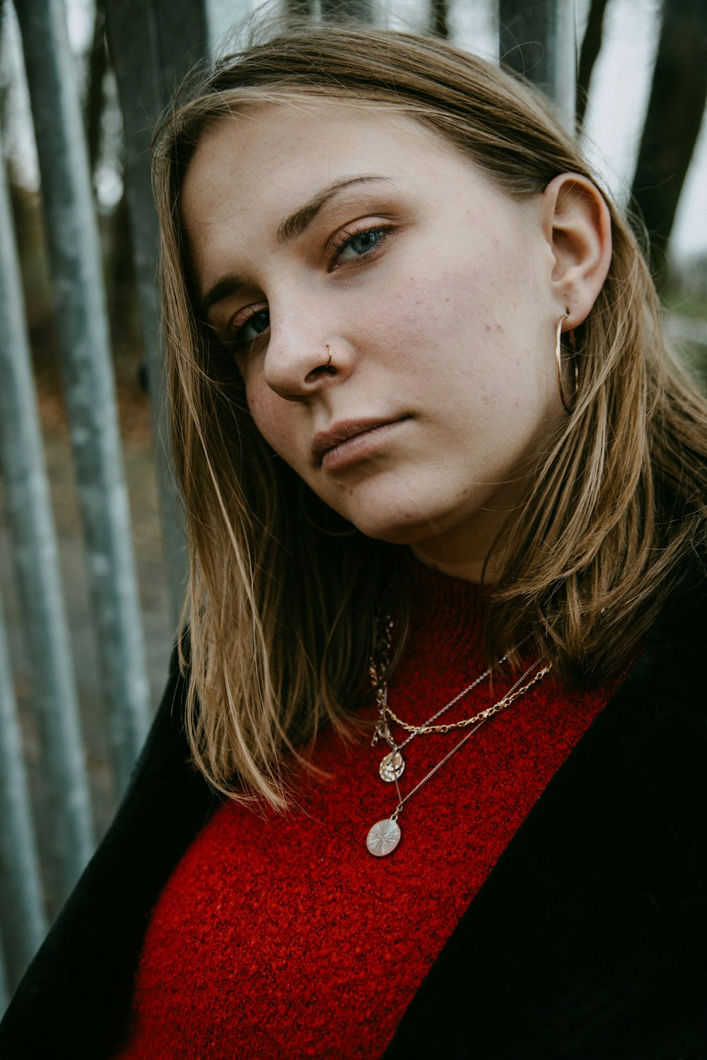 woman in red and black shirt wearing silver necklace