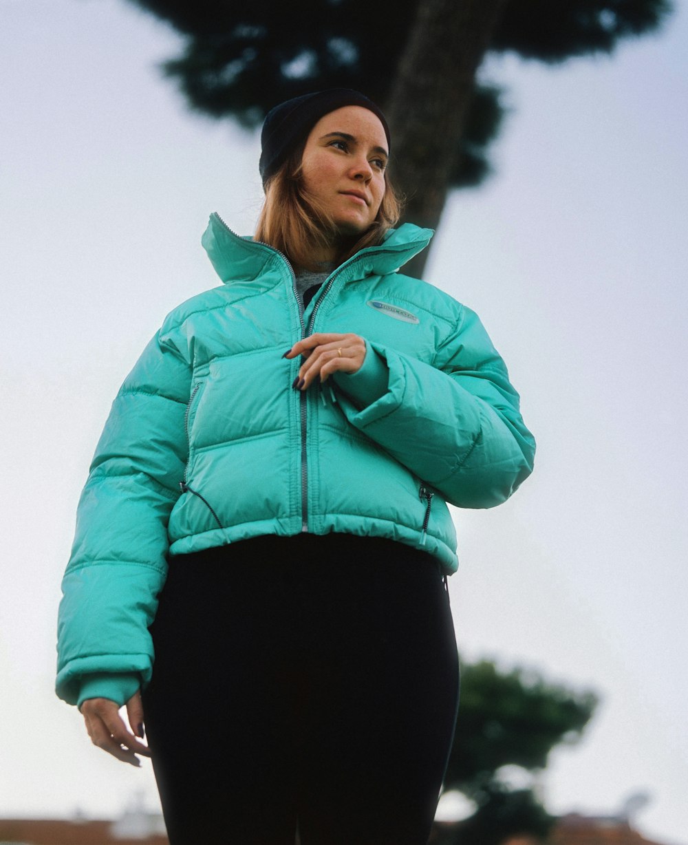 woman in teal zip up jacket and black leggings