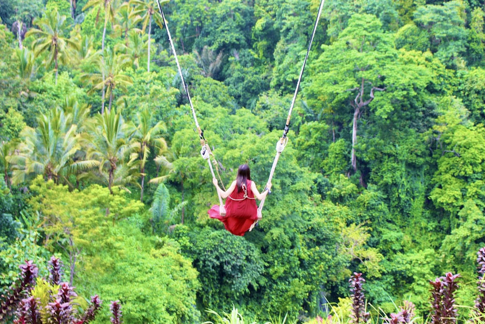 person in red jacket riding on swing