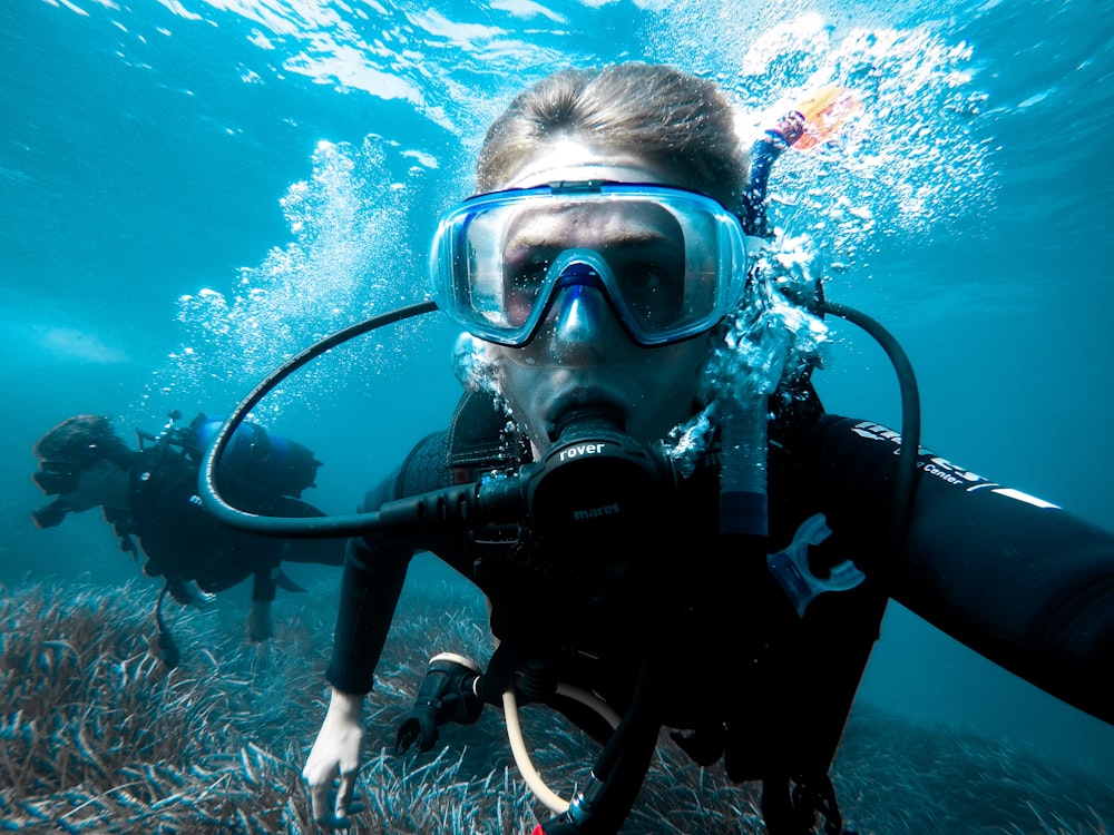 person in black and white diving suit wearing goggles