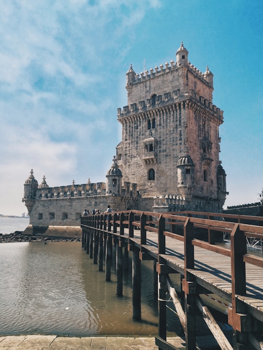 brown wooden dock on river near brown concrete building during daytime in Garden of Belem Tower Portugal