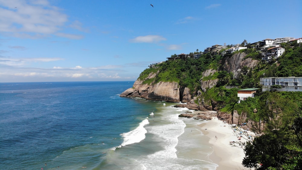 montanha verde e marrom ao lado do corpo de água durante o dia