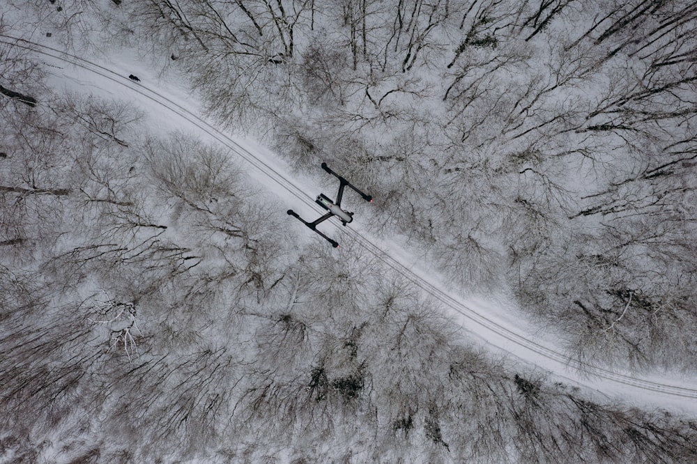 aerial view of road between trees covered with snow during daytime