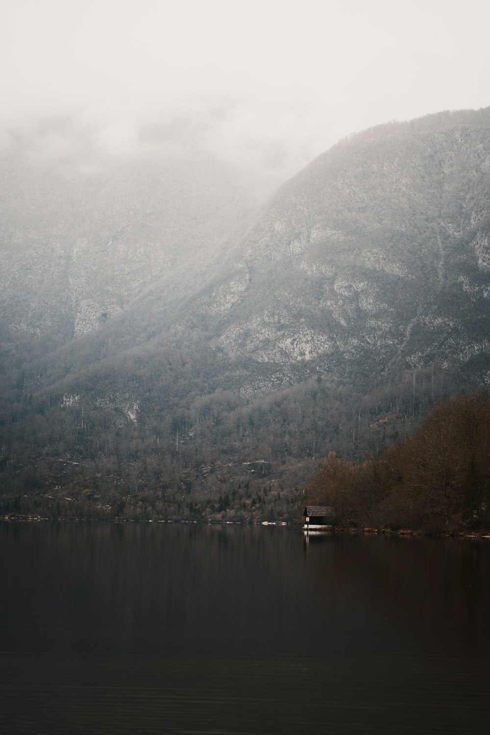 green and brown mountain beside lake during daytime