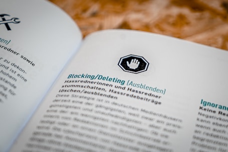 A document open to a page in German, featuring headings and text about blocking or deleting content, with an icon of a hand in a stop sign above the heading.