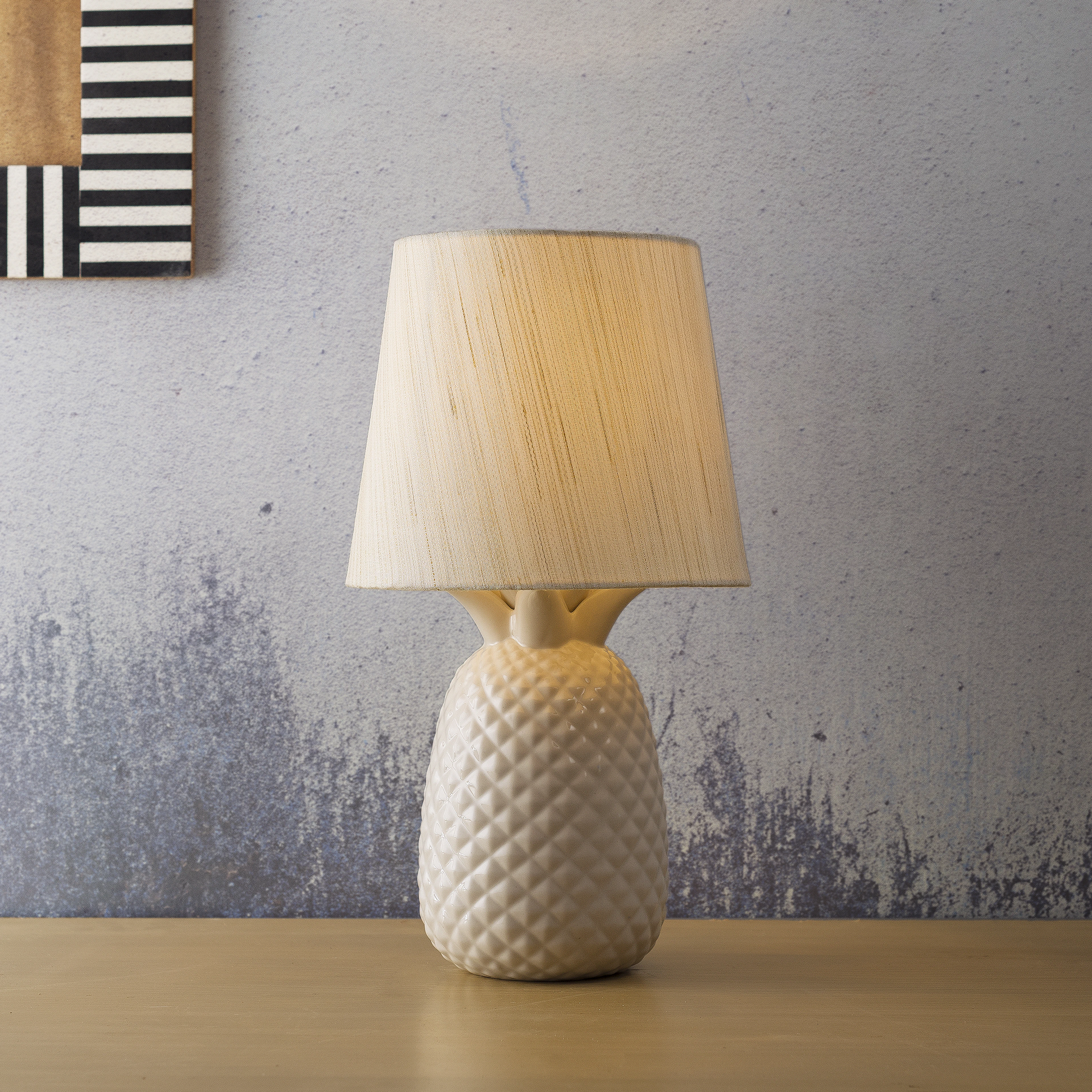 A white table lamp sitting on top of a wooden table