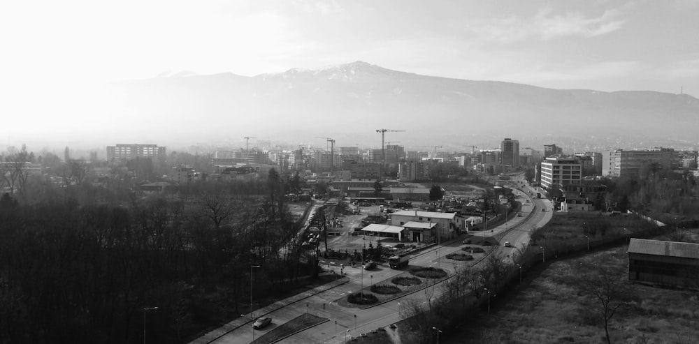 a black and white photo of a city with mountains in the background