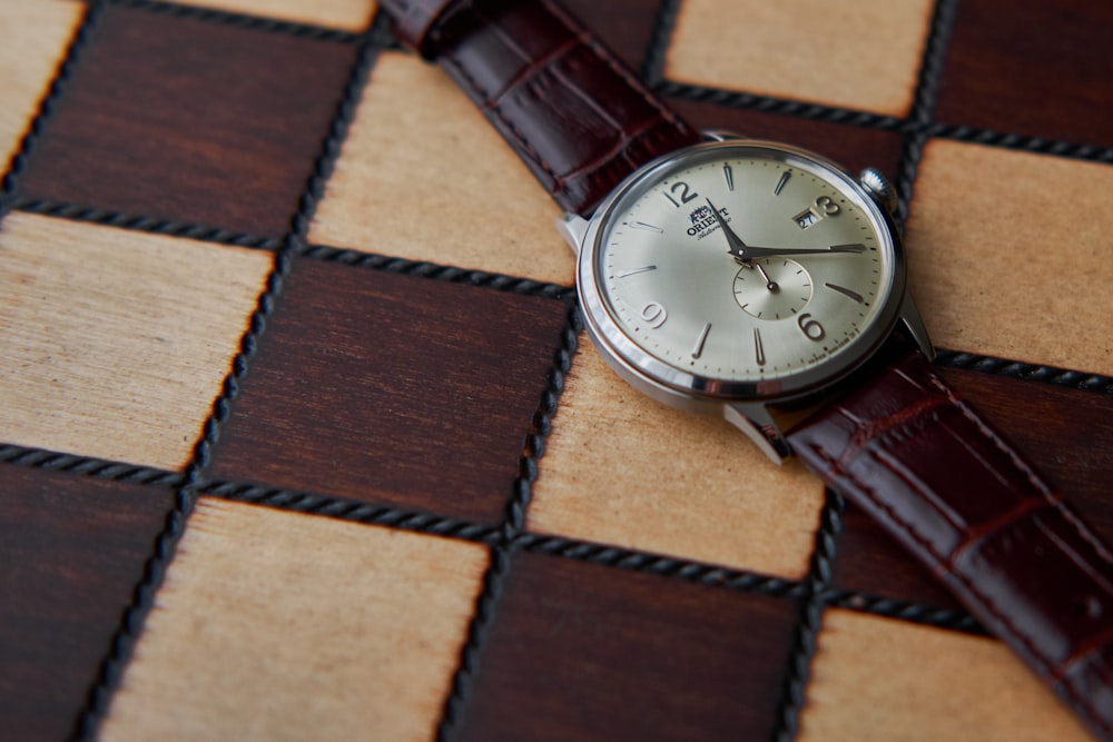 a watch sitting on top of a checkered table