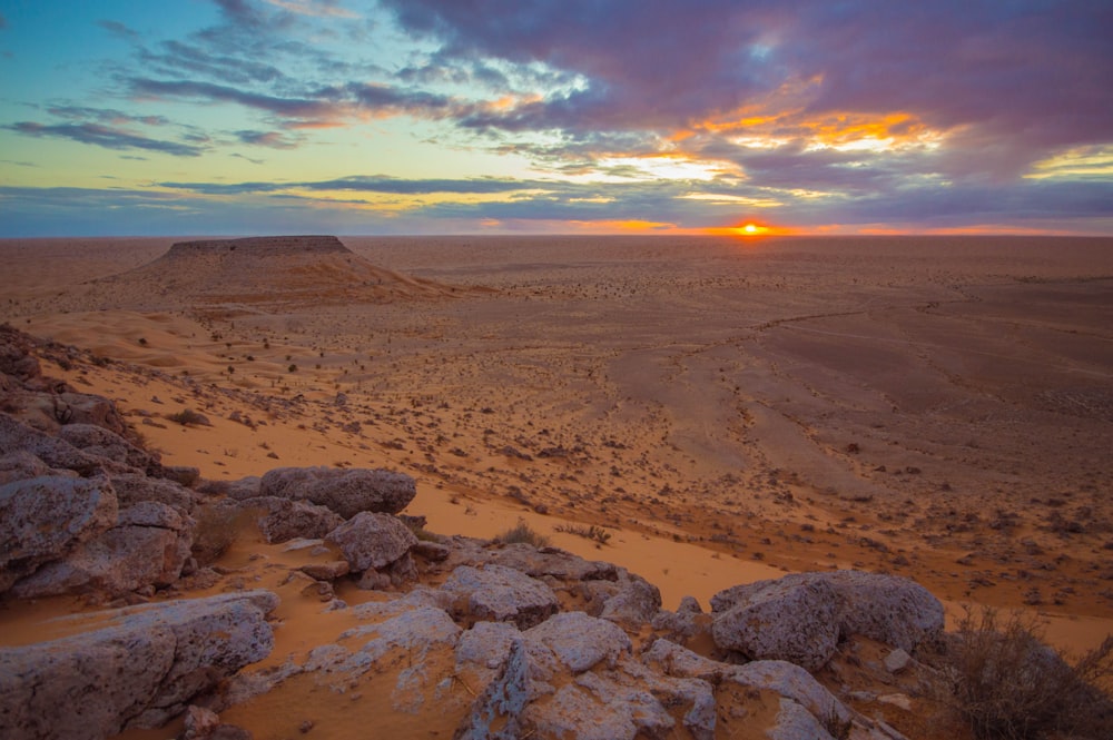 brown sand under cloudy sky during sunset
