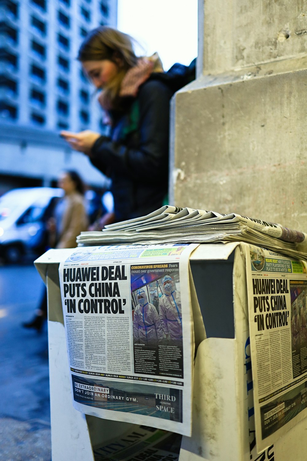 a newspaper dispenser sitting on the side of a street