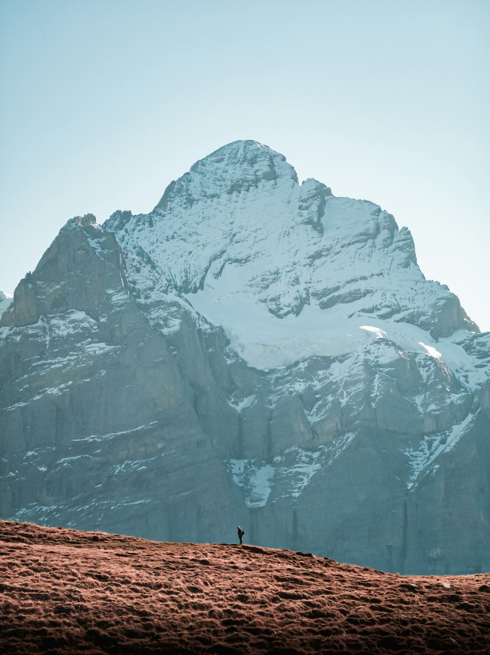 a person standing on top of a snow covered mountain