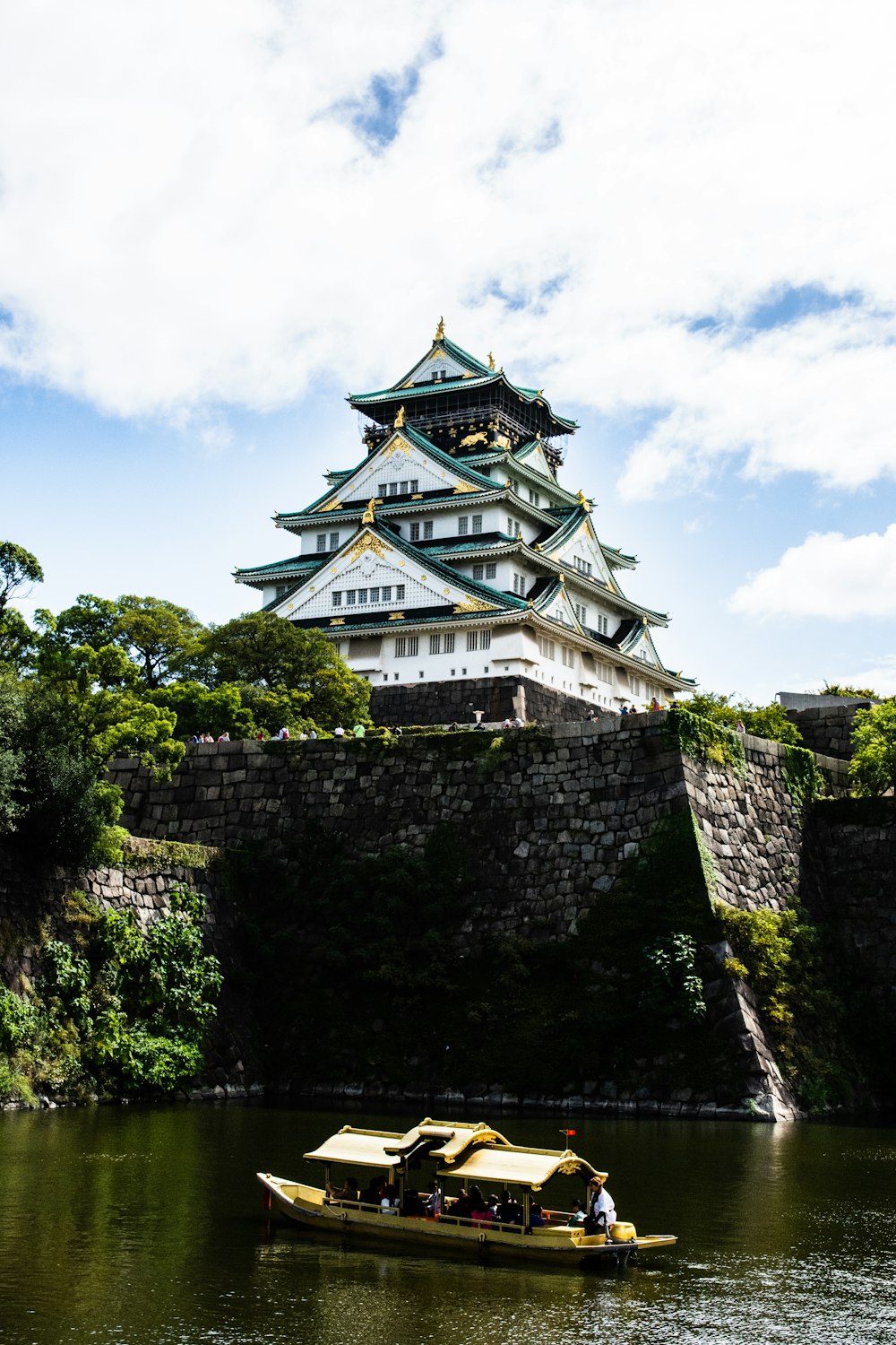 a small boat on a river in front of a castle