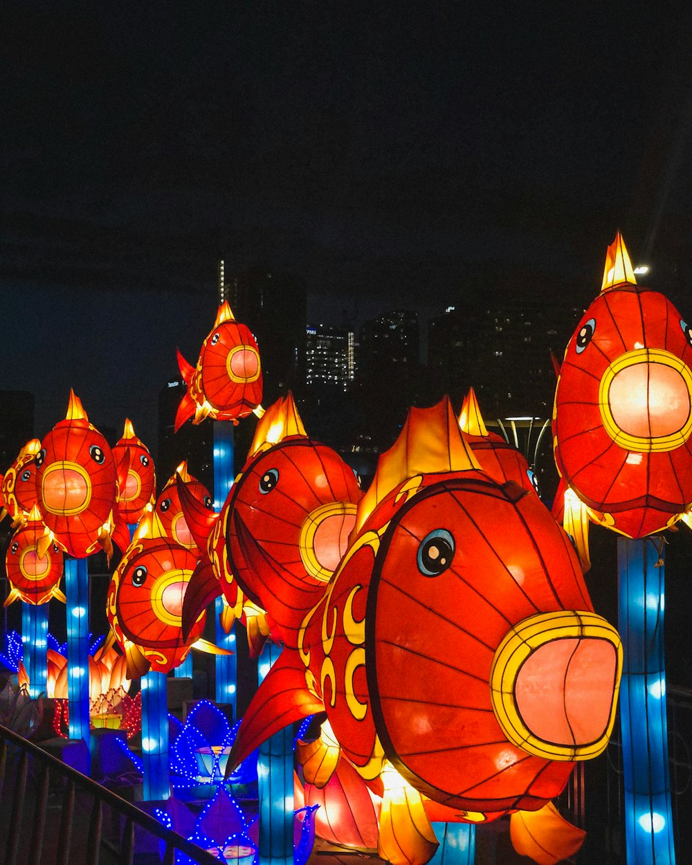 a group of red and yellow lanterns hanging from a metal fence