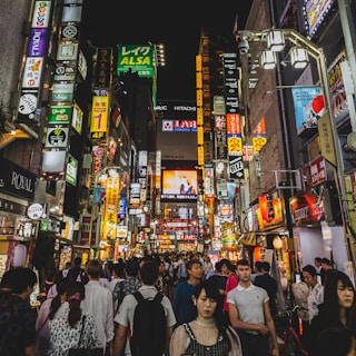 A lively urban night scene with neon lights and silhouettes of people meeting.