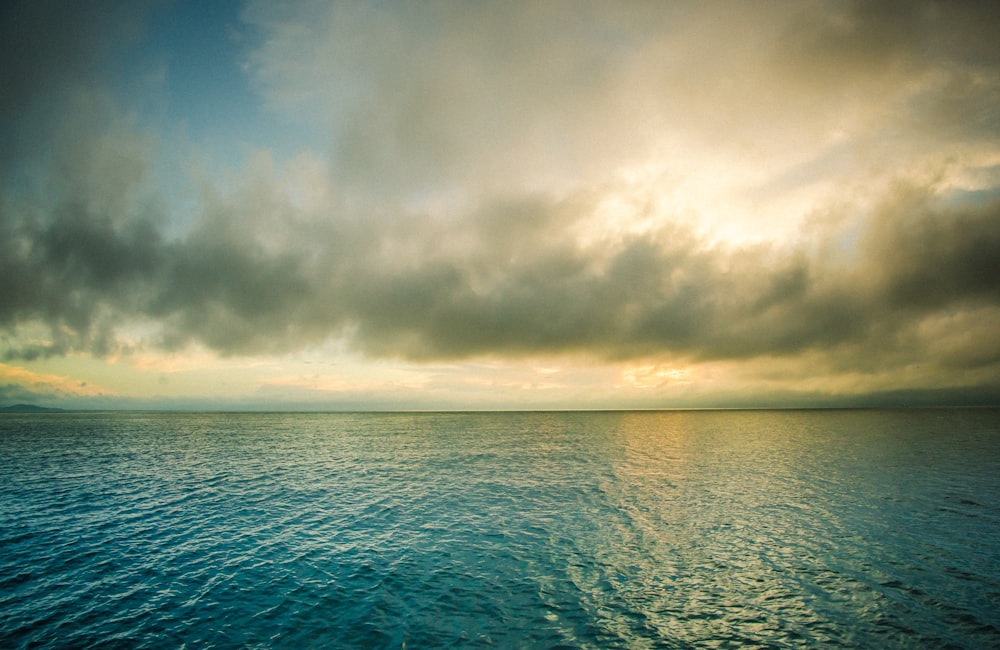 body of water under cloudy sky during daytime