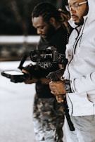 man in white jacket holding black dslr camera