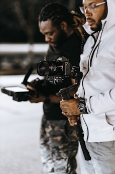 man in white jacket holding black dslr camera