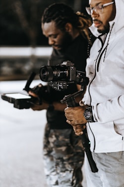 man in white jacket holding black dslr camera