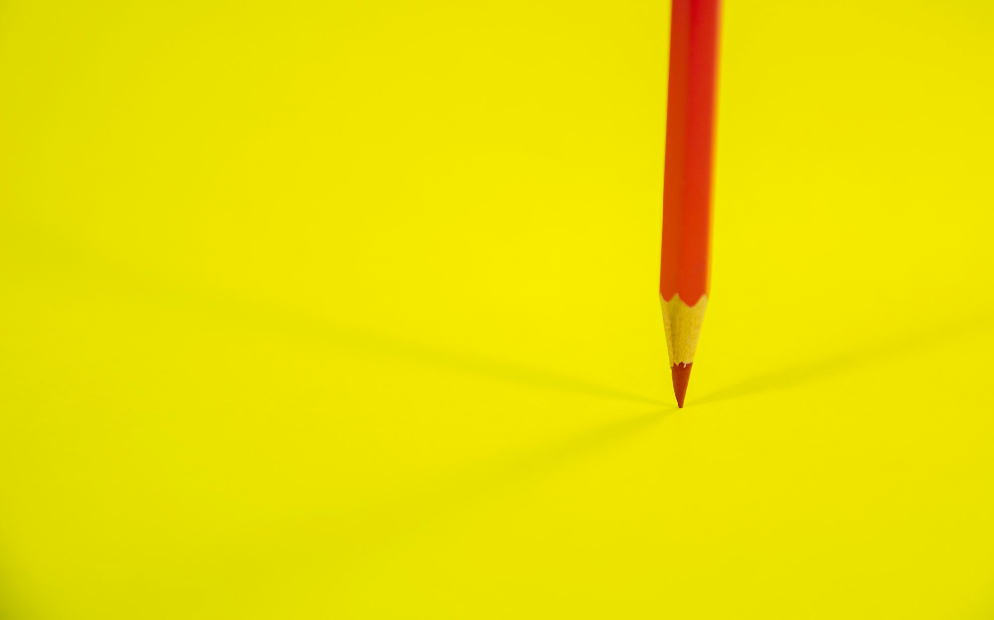 Red Color Pencil on Yellow Background 