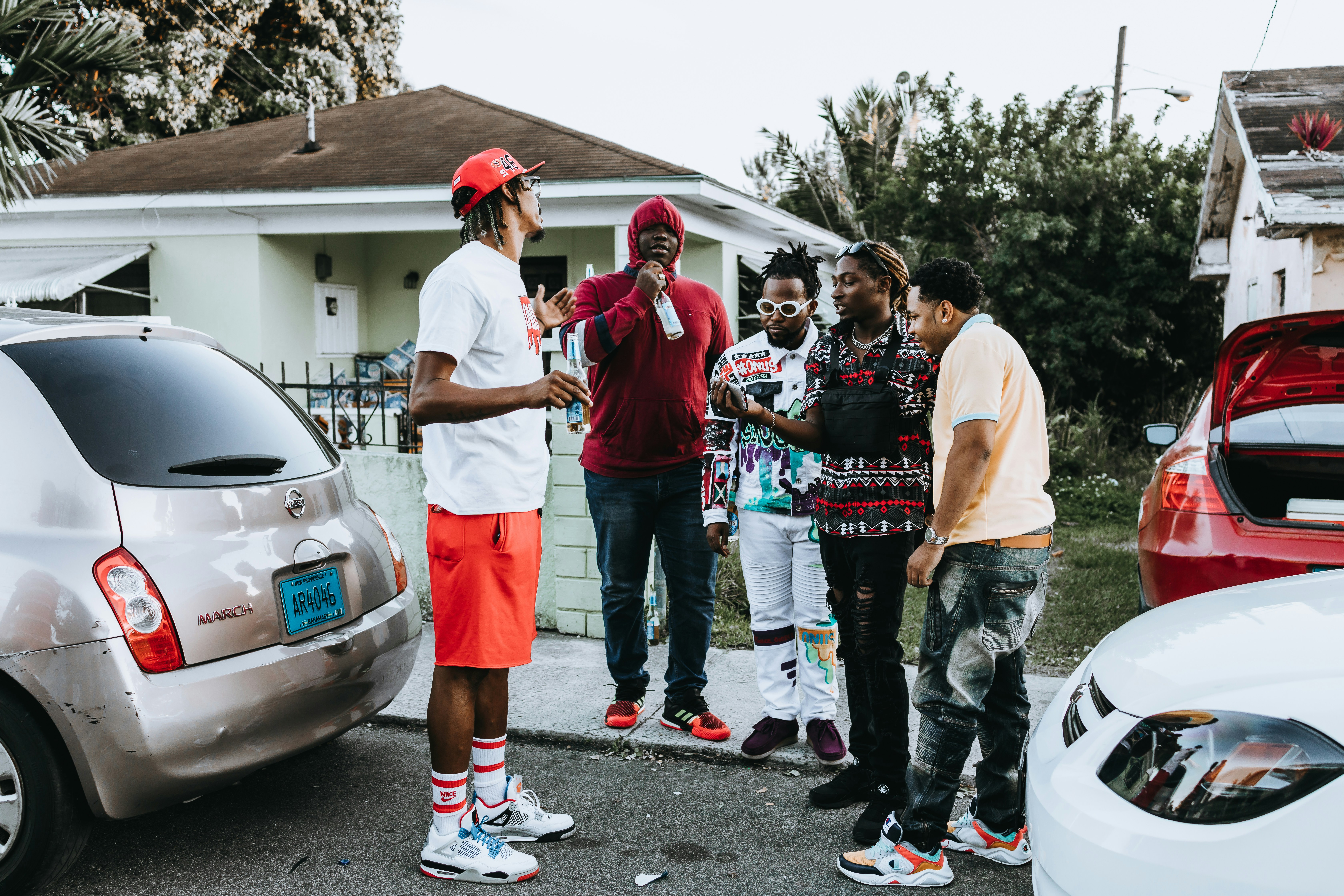 group of people standing on gray asphalt road during daytime