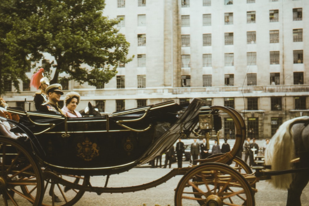 people riding on black wooden carriage during daytime