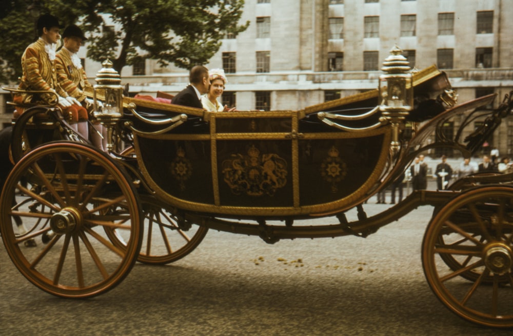 Persone che cavalcano su una carrozza di legno marrone durante il giorno