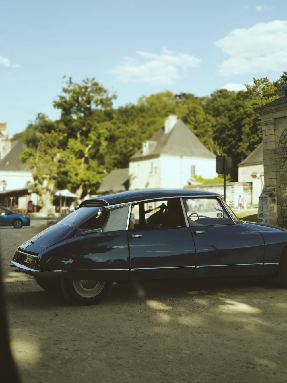 black sedan parked beside blue car during daytime