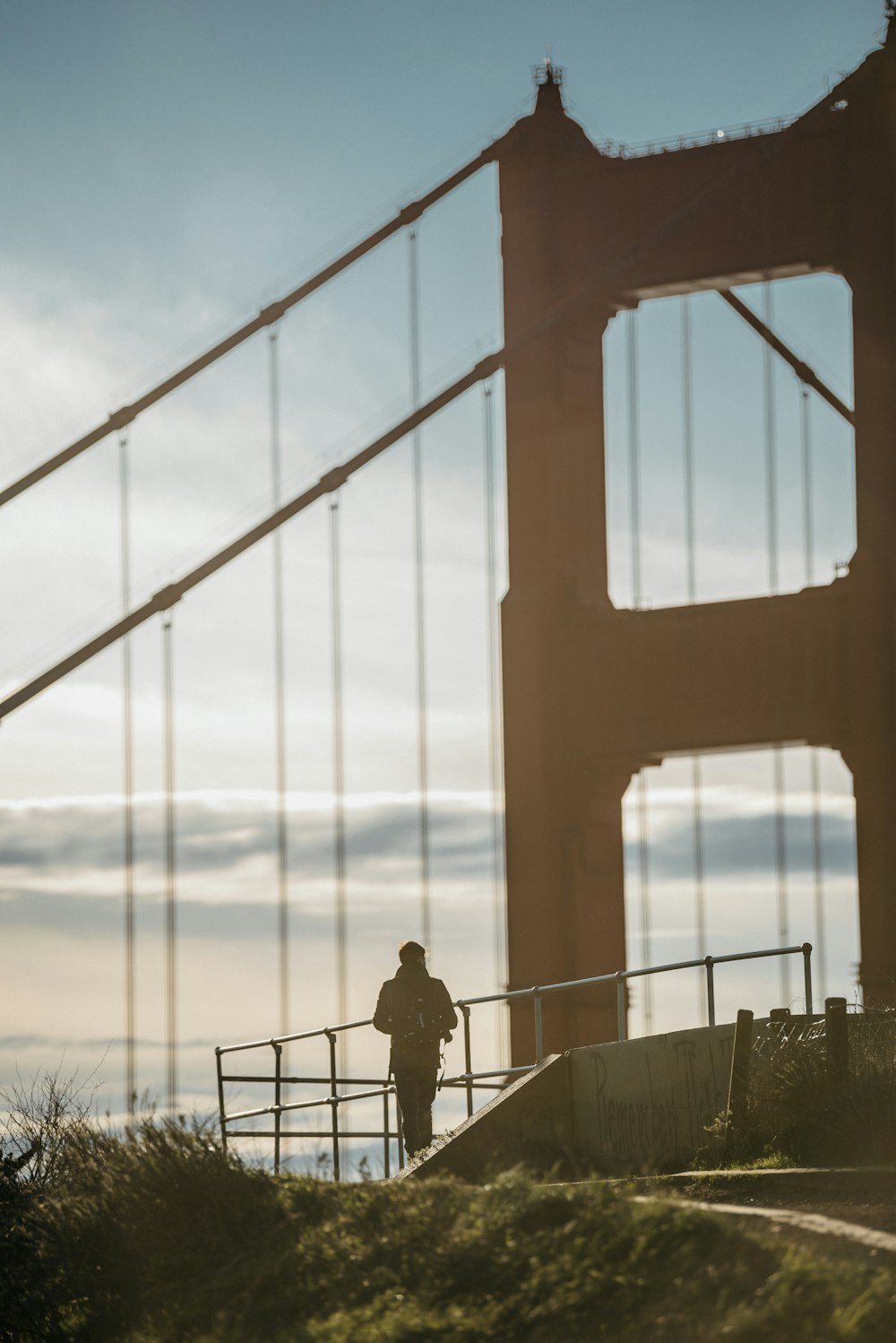 man in black jacket standing on bridge during daytime