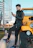 Young man checking his phone while waiting comfortably beside a sleek black cab.