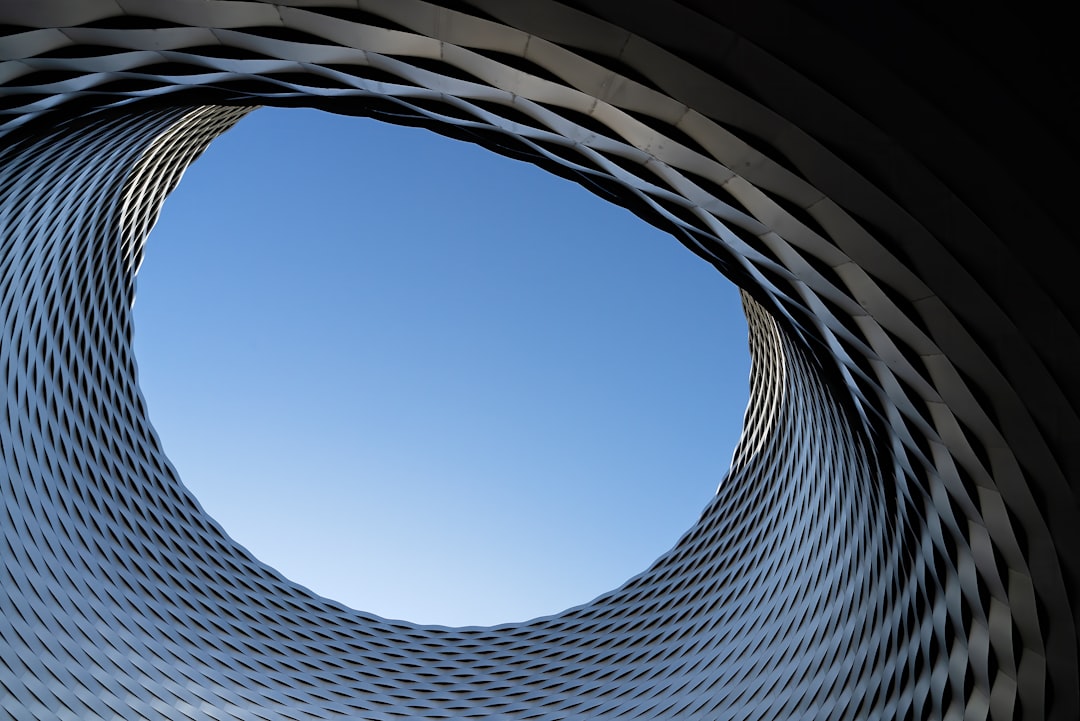 low angle photography of gray concrete building under blue sky during daytime