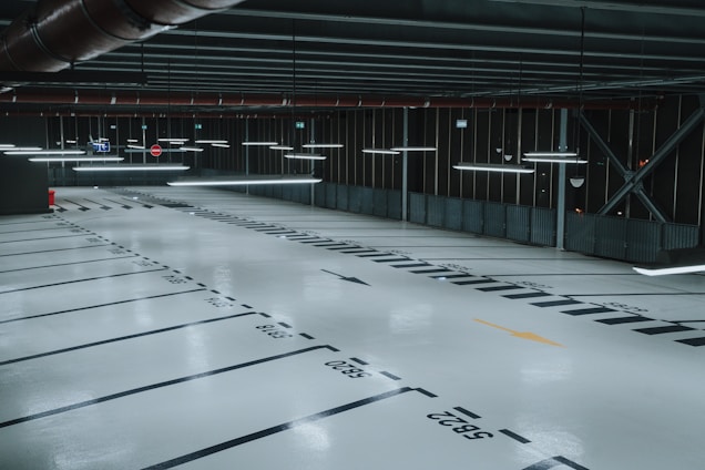 A clean, well-lit parking garage with several cars parked in designated spots.