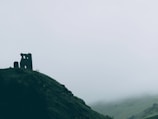A misty morning over old Scottish castle ruins beside a calm loch.