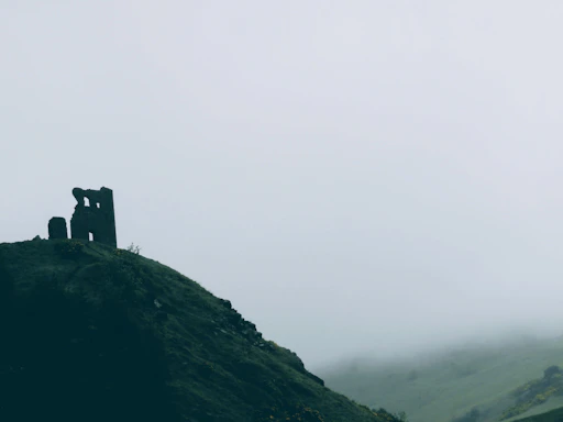 A candid shot of the photographer capturing a misty ancient castle at dawn.