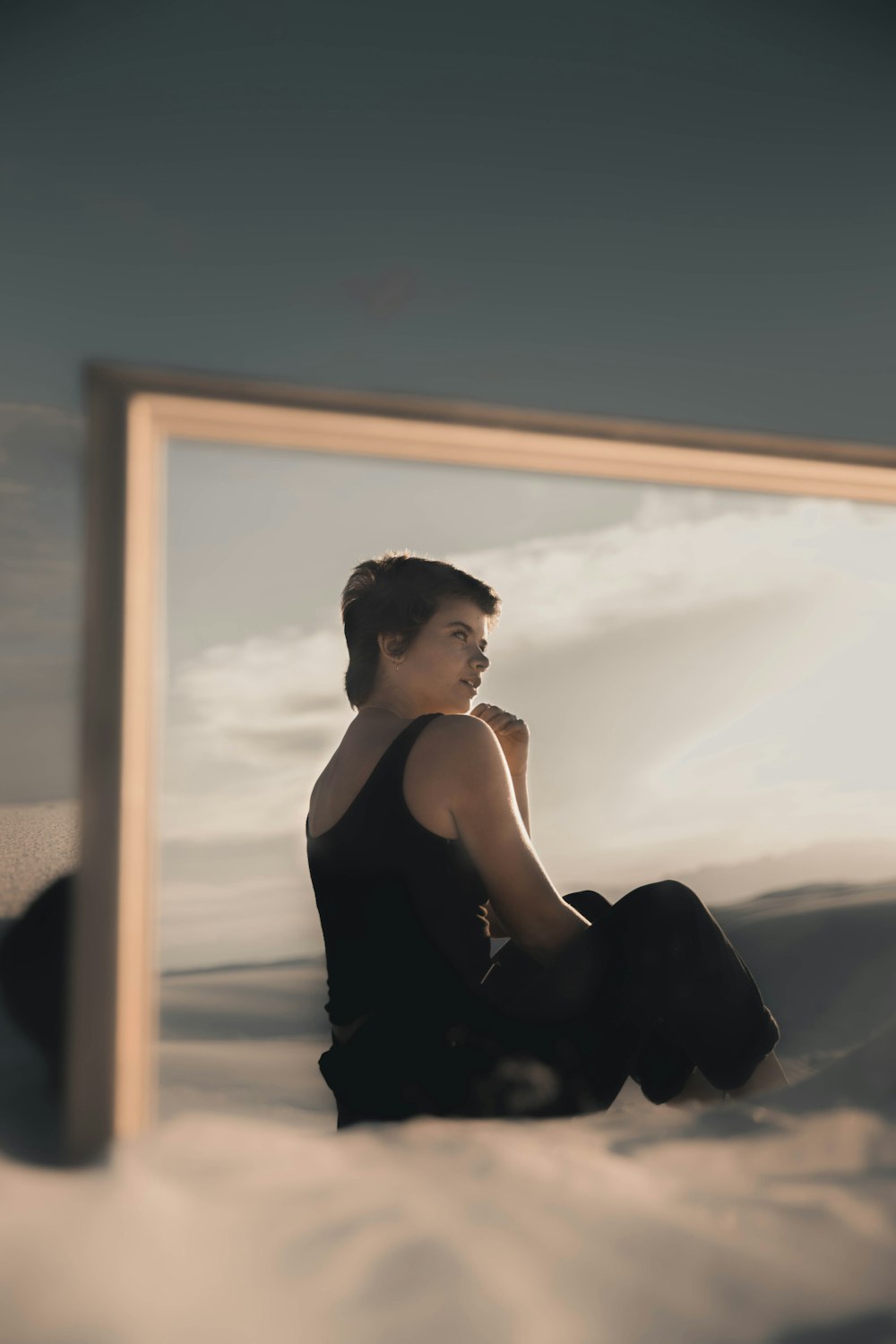 woman in black tank top sitting on window during daytime