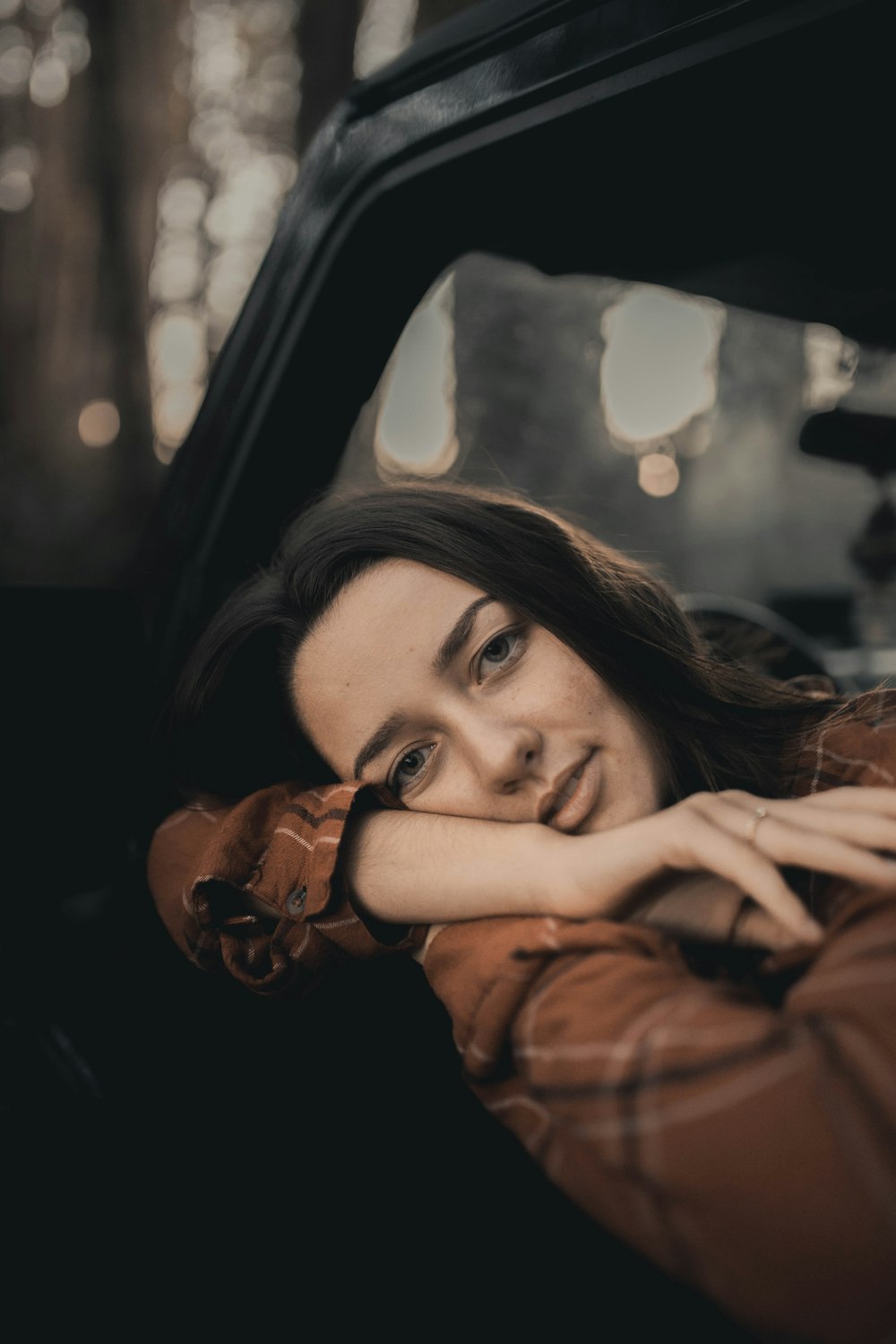 woman in brown leather jacket wearing black framed eyeglasses