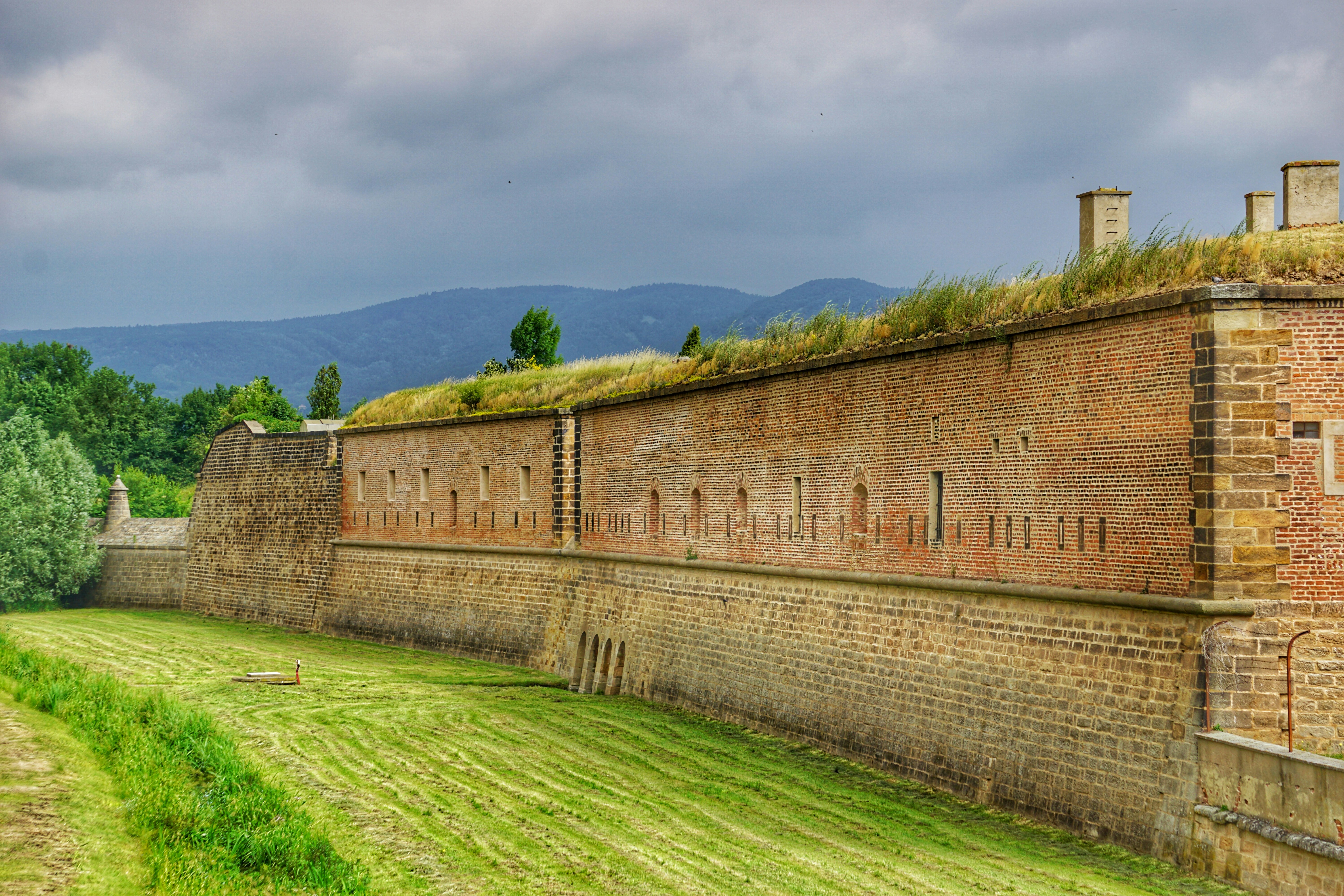 edificio in mattoni marroni su campo di erba verde