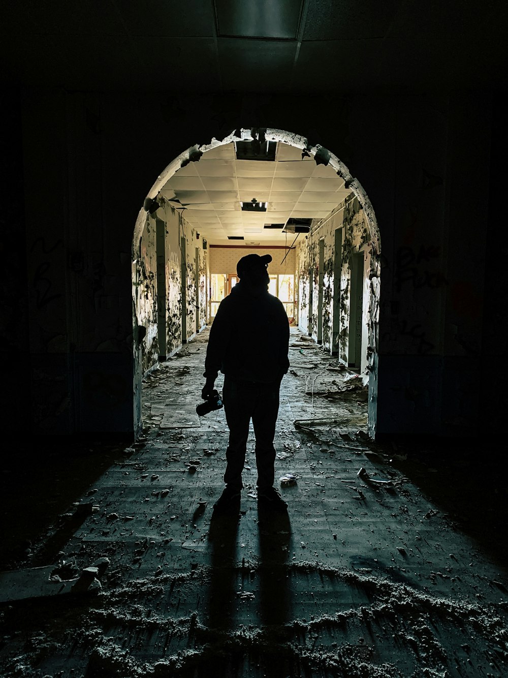 man in black jacket walking on tunnel during daytime