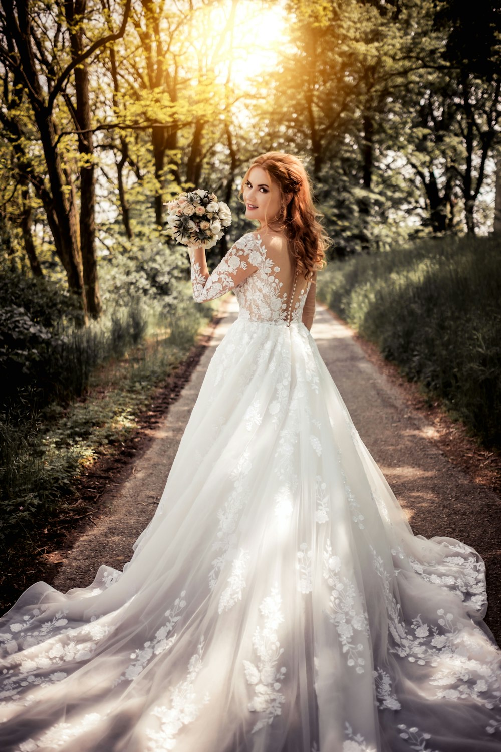 mujer en vestido floral blanco de pie en suelo marrón rodeado de plantas y árboles verdes durante