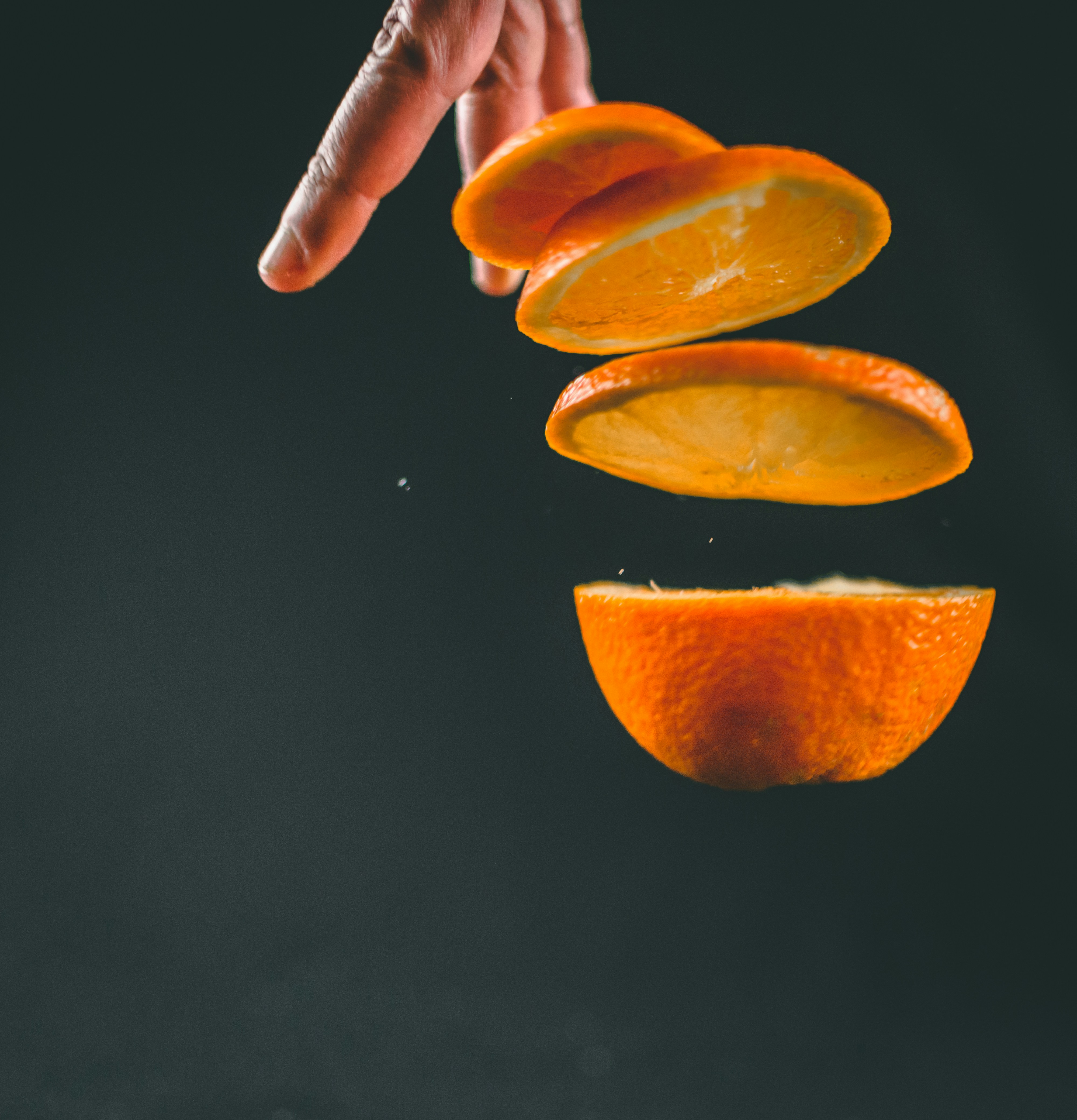Levitating slices of orange on black background